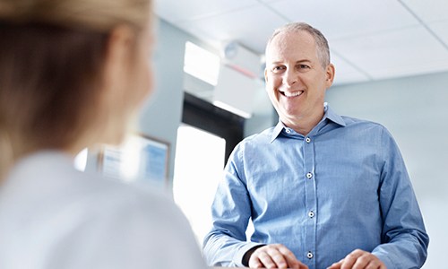 Man discussing flexible payment options with dental team member