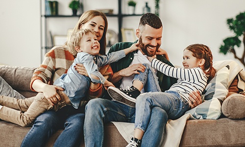 Mother father and two children laughing together after dental office visit