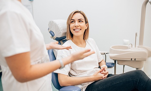 Woman in dental chair smiling at dentist