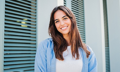 Woman with white teeth smiling while standing outside