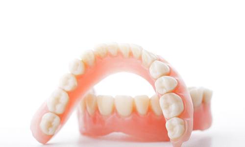 Closeup of full dentures in Webster on a white background