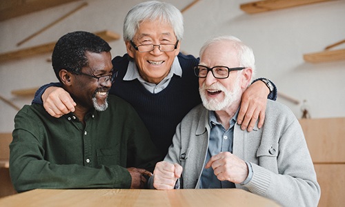 Group of senior men smiling and hugging