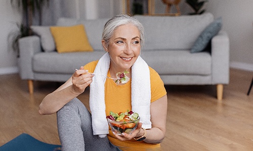 Closeup of woman smiling while eating post-workout meal