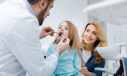 Webster family dentist checking girl’s teeth 