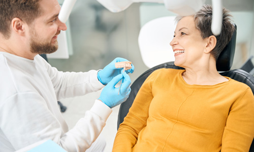 Dentist going over dentures with female patient 