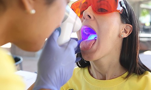 Dentist performing oral cancer screening