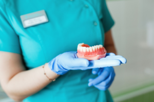 a dental hygienist holding a denture  
