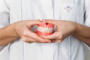 a closeup of a hand holding dentures