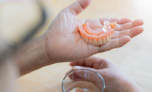 a patient holding their dentures